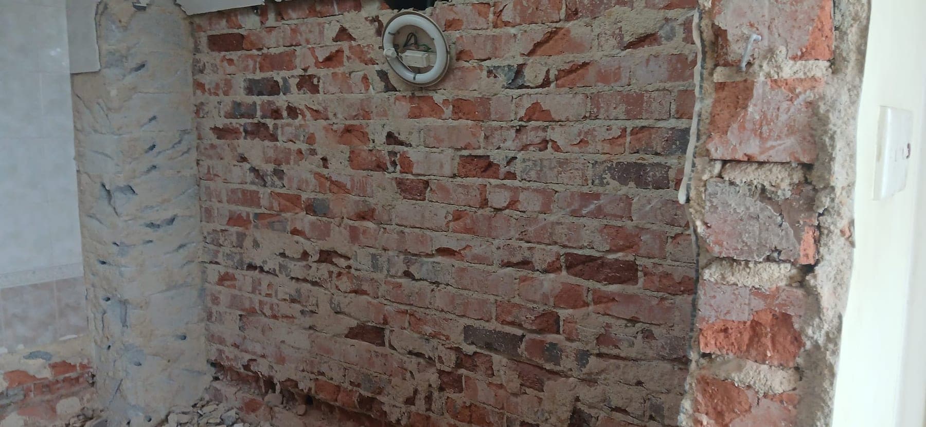 Wide exposed brick wall after hacking works on a JBC demo site