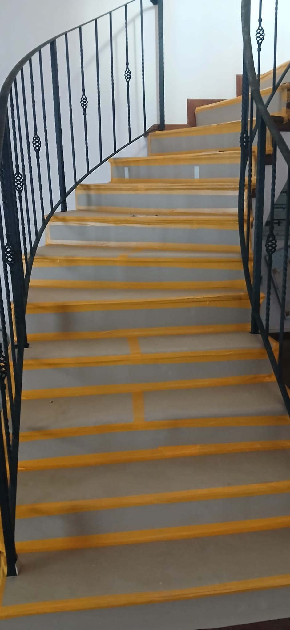 Staircase protected with floor covering and yellow tape before demo works